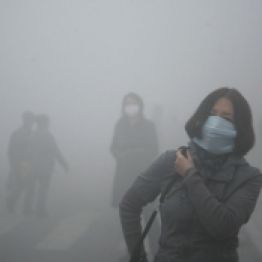 A woman wearing a mask walk through a street covered by dense smog in Harbin, northern China, Monday, Oct. 21, 2013. Visibility shrank to less than half a football field and small-particle pollution soared to a record 40 times higher than an international safety standard in one northern Chinese city as the region entered its high-smog season. (AP Photo/Kyodo News) JAPAN OUT, MANDATORY CREDIT